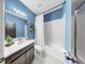 Cozy bathroom featuring blue walls, a white shower curtain, and dark vanity with a sink at 17610 Buckingham Garden Dr, Lithia, FL 33547