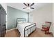 Bedroom featuring a black metal bed frame, rocking chair, and ceiling fan at 17610 Buckingham Garden Dr, Lithia, FL 33547