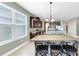 Dining room with large window, long table, and view into the kitchen area at 17610 Buckingham Garden Dr, Lithia, FL 33547