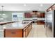 Kitchen featuring a large island with granite countertops and stainless steel appliances at 17610 Buckingham Garden Dr, Lithia, FL 33547