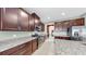 Modern kitchen with a large center island, brown cabinets and stainless steel appliances at 17610 Buckingham Garden Dr, Lithia, FL 33547