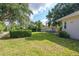 Spacious backyard with lush greenery, a detached garage, and a partial view of the main house at 1815 Durant Rd, Valrico, FL 33596