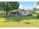 Expansive backyard featuring a well-maintained lawn, a fenced perimeter, and a charming home exterior at 1815 Durant Rd, Valrico, FL 33596