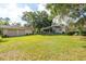 Large backyard with mature trees, a lush green lawn, a detached garage, and fenced perimeter at 1815 Durant Rd, Valrico, FL 33596