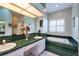 Bathroom featuring double sinks, green tile countertops and bathtub surround, and natural light at 1815 Durant Rd, Valrico, FL 33596