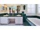 Bright bathroom boasts a tiled tub and double sinks with green tile counters and white cabinets at 1815 Durant Rd, Valrico, FL 33596