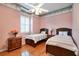 Charming bedroom featuring twin beds, hardwood floors, and decorative wallpaper border at 1815 Durant Rd, Valrico, FL 33596