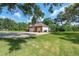 Large detached garage featuring a brick facade, multiple doors, and ample parking at 1815 Durant Rd, Valrico, FL 33596