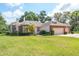 Charming brick home featuring a two-car garage, manicured lawn, and mature landscaping at 1815 Durant Rd, Valrico, FL 33596