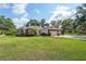 Charming brick home featuring a two-car garage, manicured lawn, and mature landscaping at 1815 Durant Rd, Valrico, FL 33596