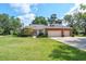 Charming brick home featuring a two-car garage, manicured lawn, and mature landscaping at 1815 Durant Rd, Valrico, FL 33596