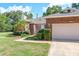 Charming brick home featuring a two-car garage, manicured lawn, and mature landscaping at 1815 Durant Rd, Valrico, FL 33596