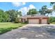 Charming brick home featuring a two-car garage, manicured lawn, and mature landscaping at 1815 Durant Rd, Valrico, FL 33596