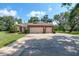 Charming brick home featuring a two-car garage, manicured lawn, and mature landscaping at 1815 Durant Rd, Valrico, FL 33596