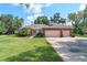 Charming brick home featuring a two-car garage, manicured lawn, and mature landscaping at 1815 Durant Rd, Valrico, FL 33596
