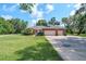 Charming brick home featuring a two-car garage, manicured lawn, and mature landscaping at 1815 Durant Rd, Valrico, FL 33596