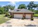 Spacious three-car garage with an expansive driveway and beautiful landscaping at 1815 Durant Rd, Valrico, FL 33596