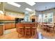 Open kitchen features a central island with seating, wood cabinets, and a dining area at 1815 Durant Rd, Valrico, FL 33596