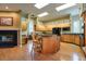 Warm kitchen with wood cabinets, black granite countertops, island seating, and a fireplace at 1815 Durant Rd, Valrico, FL 33596