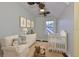 Cozy Bedroom with hardwood floors, ample natural light, neutral decor, and a crib plus rocking chair at 1825 2Nd S St, St Petersburg, FL 33705