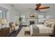 Bright bedroom features a ceiling fan, a fireplace, a cozy chair, and a large bed with neutral bedding at 1825 2Nd S St, St Petersburg, FL 33705