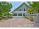Paved brick driveway, mature landscaping, and a view of the home's charming features at 1825 2Nd S St, St Petersburg, FL 33705