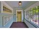 Inviting front porch featuring a vibrant yellow door with decorative trim and lighting at 1825 2Nd S St, St Petersburg, FL 33705