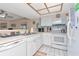 Kitchen with white cabinets and appliances, and an adjacent living room at 18400 Gulf Blvd # 2505, Indian Shores, FL 33785