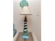 Close up of a lighthouse themed table lamp on a glass top table next to a light switch at 18400 Gulf Blvd # 2505, Indian Shores, FL 33785