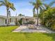 Backyard has a firepit, covered patio with furniture, and tropical landscaping at 2016 Cove Dr, Largo, FL 33774