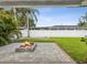 Backyard features a firepit, green grass, tropical plants, and a privacy fence at 2016 Cove Dr, Largo, FL 33774
