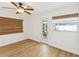 Neutral bedroom with light colored wood floors, ceiling fan, and natural woven window coverings at 2016 Cove Dr, Largo, FL 33774