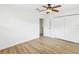 A spacious bedroom with wood flooring, ceiling fan, double door closet, and a window at 2016 Cove Dr, Largo, FL 33774