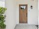 Stylish front door with a glass panel and a modern exterior light fixture at 2016 Cove Dr, Largo, FL 33774