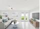 Bright living room with white furniture, French doors to the yard, and entertainment console at 2016 Cove Dr, Largo, FL 33774