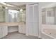 Bathroom with double vanity, soaking tub, and mirrored walls at 2120 S Hesperides St, Tampa, FL 33629