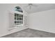 Bedroom featuring an arched window, ceiling fan, white walls, and neutral carpet at 2120 S Hesperides St, Tampa, FL 33629