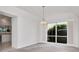 Dining room with a chandelier and view of backyard landscaping through large windows at 2120 S Hesperides St, Tampa, FL 33629