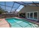 Sparkling swimming pool with screened enclosure and outdoor seating area at 2120 S Hesperides St, Tampa, FL 33629