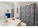 Clean bathroom with a floral shower curtain, vanity with sink, and a mirror with lighting fixtures at 2218 Brookfield Greens Cir # 82, Sun City Center, FL 33573