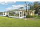 Back exterior view of home with a sunroom overlooking lush lawn at 2218 Brookfield Greens Cir # 82, Sun City Center, FL 33573