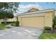Attached two-car garage with a concrete driveway and well manicured lawn with garden at 2218 Brookfield Greens Cir # 82, Sun City Center, FL 33573