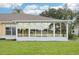 Enclosed sunroom features sliding windows and views of the lake in a private backyard at 2218 Brookfield Greens Cir # 82, Sun City Center, FL 33573