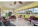 Relaxing sunroom with tile flooring, comfortable seating, and serene views of the surrounding lake and landscape at 2218 Brookfield Greens Cir # 82, Sun City Center, FL 33573