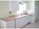 White kitchen with white cabinets, light countertops, and stainless steel sink at 2325 Brookfield Greens Cir # 41, Sun City Center, FL 33573