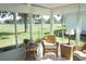 Comfortable sunroom with wicker chairs, white tile floors, and a view of the lush green lawn at 2325 Brookfield Greens Cir # 41, Sun City Center, FL 33573