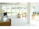 Bright sunroom with wicker furniture, white tile floors, and large windows overlooking the green lawn at 2325 Brookfield Greens Cir # 41, Sun City Center, FL 33573