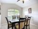 Cozy dining area features a ceiling fan, expansive window, and stylish dark wood table with upholstered chairs at 2601 Brookville Dr, Valrico, FL 33596
