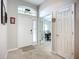 Welcoming foyer featuring neutral-toned tile flooring, a front door with transom window, and a view into the dining area at 2601 Brookville Dr, Valrico, FL 33596