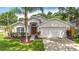 Charming single-story home featuring a well-maintained lawn, lush landscaping, and an attached two-car garage at 2601 Brookville Dr, Valrico, FL 33596